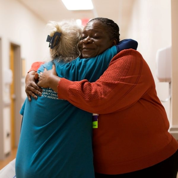 A touching photo of an NCIMHA member hugging a grateful caregiver.